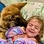 dog, child, smiling, laughing, cute, fluffy, pet, cuddle, blanket, indoor, cozy, happy, face, young_girl, pillow, furniture, bedroom, affection, comfort, playful