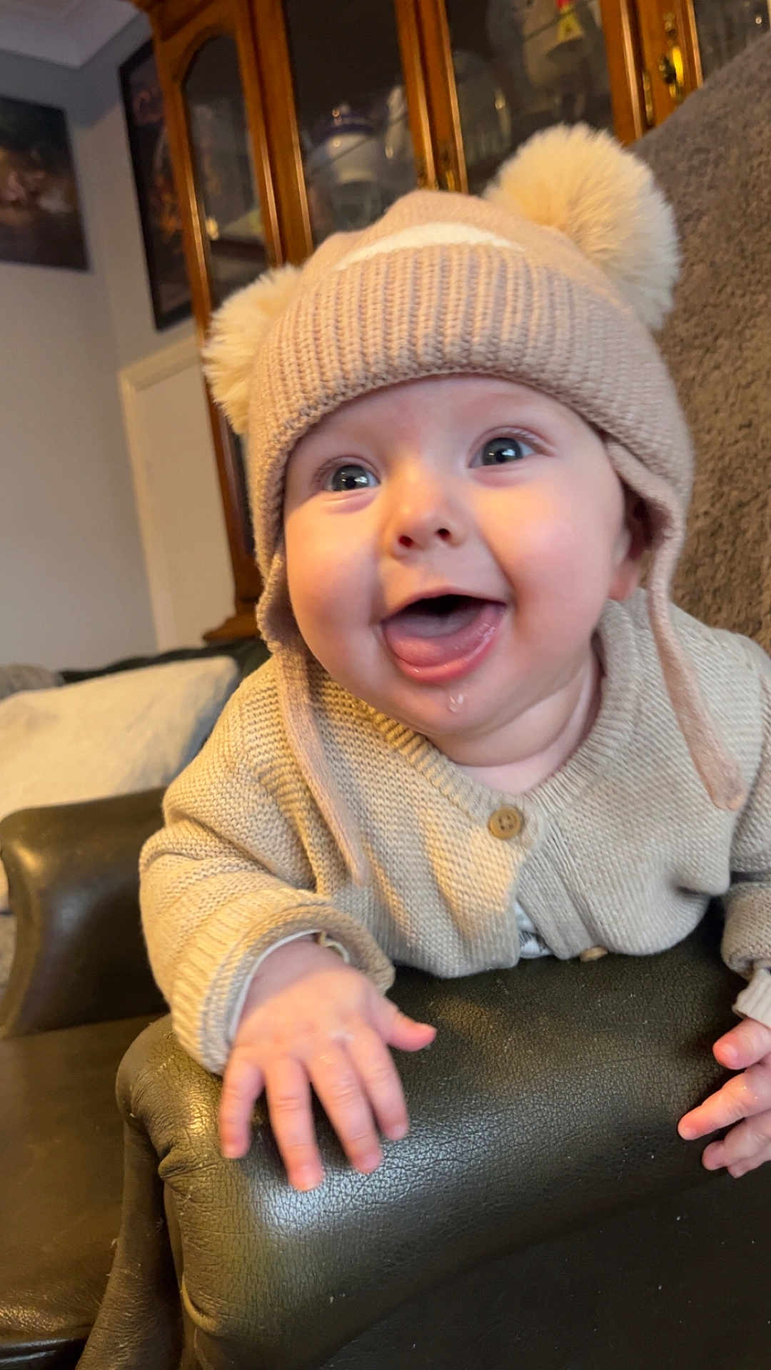 Hunter joined the competition — help win amazing prizes! baby, child, smiling, happy, hat, knit_hat, pom_poms, sweater, drool, armrest, chair, leather, indoor, home, furniture, cute, portrait, person, infant, cozy