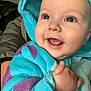 Hunter is registered to the contest to win money with this photo: baby, child, smiling, hooded_clothing, blue_clothing, purple_clothing, happy, cute, infant, face, portrait, person, hand, warm_clothing, indoor, holding, expression, closeup, jacket, young