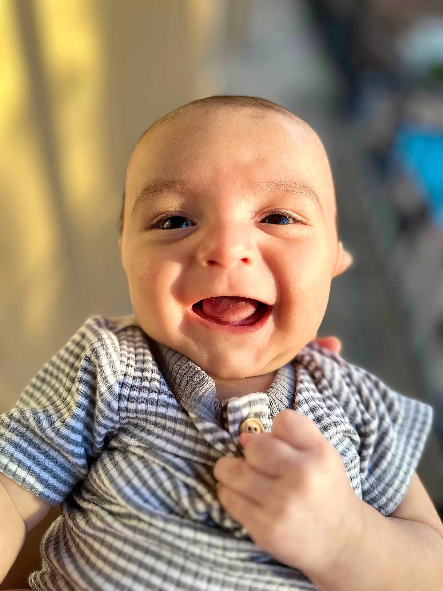 Austin is registered to the contest to win money with this photo: baby, smiling, happy, infant, face, child, portrait, striped_shirt, hand, skin, cute, young, person, indoors, closeup, expression, cheerful, light, warm, blurry_background