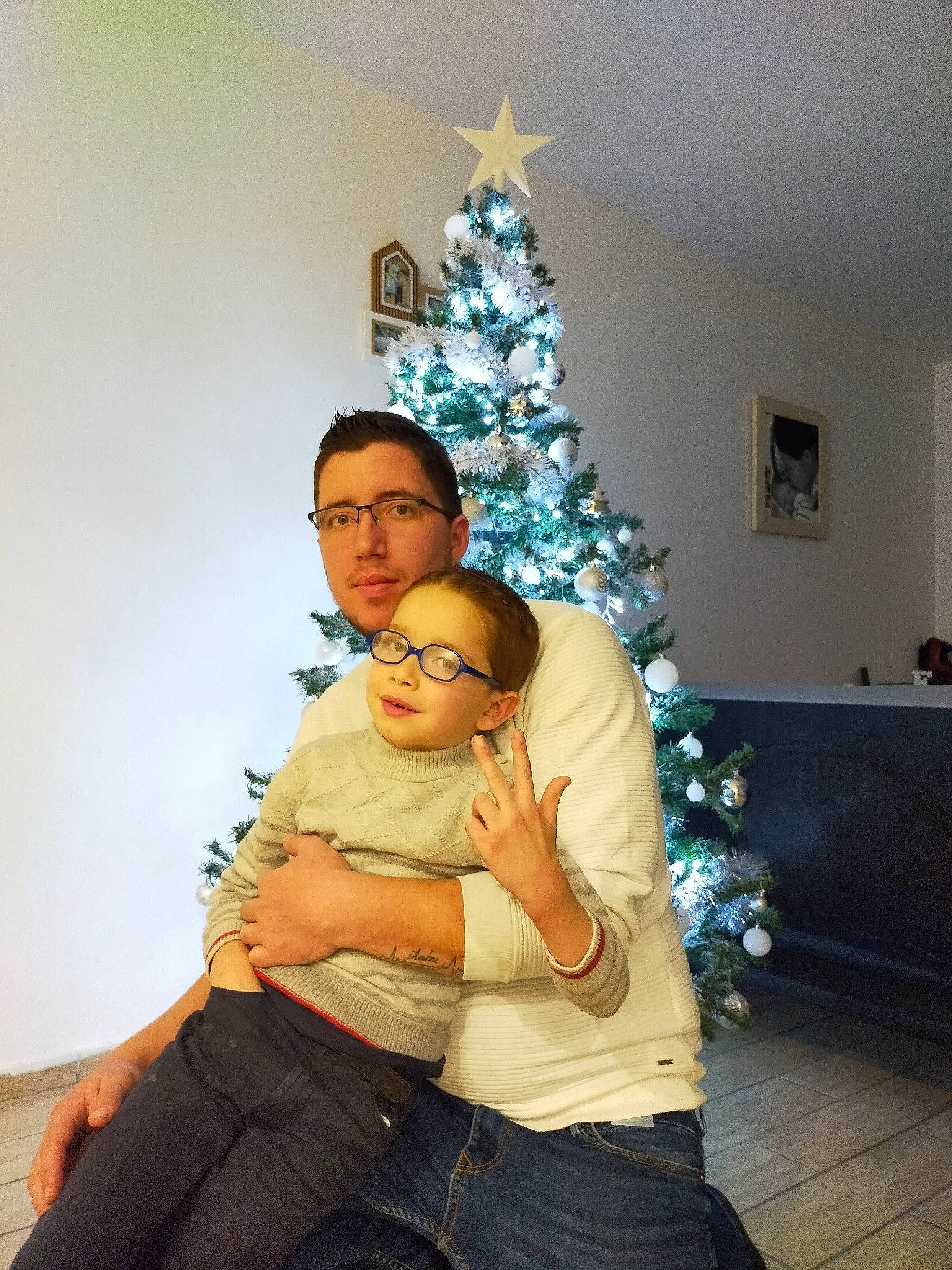 Enzo participe au concours pour gagner de l'argent avec cette photo : architecture, blue, christmas_decoration, clothing, event, fun, glasses, green, head, human, interior_design, leg, lighting, people, person, room, sitting, vertebrate, winter, wood