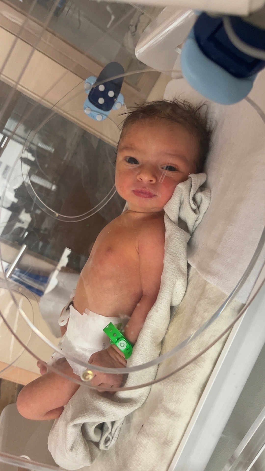 Nahyl participe au concours pour gagner de l'argent avec cette photo : baby, curious, cute, diaper, face, healthcare, hospital, hospital_bracelet, incubator, indoors, infant, lying_down, medical_equipment, newborn, patient, person, skin, small, towel, wrapping