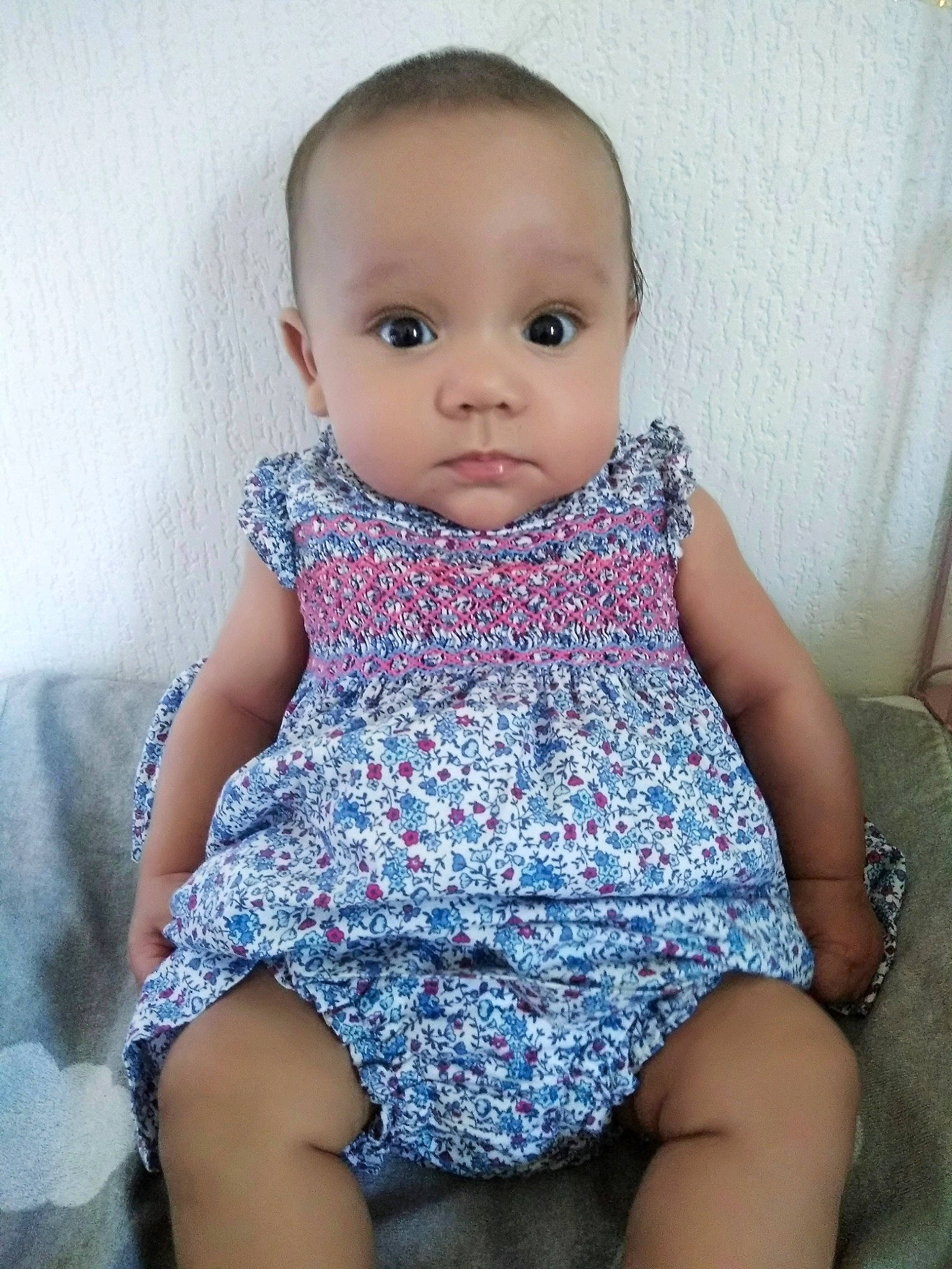 Alma participe au concours pour gagner de l'argent avec cette photo : baby, baby_toddler_clothing, cheek, child, dress, face, head, leg, lip, pattern, person, pink, sitting, skin, toddler