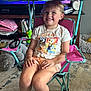 Lucy joined the competition — help win amazing prizes! child, smiling, indoor, chair, pink, turquoise, tshirt, shorts, carpet, television, toy, furniture, person, happy, cute, kid, room, sitting, footwear, living_room