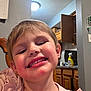 Lucy joined the competition — help win amazing prizes! child, smiling, face, indoor, kitchen, wooden_chair, cabinet, spray_bottle, light_fixture, calendar, pink_clothing, happy, person, portrait, hair, teeth, skin, furniture, expression, young