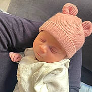 Sihem participe au concours pour gagner de l'argent avec cette photo : arm, baby, blanket, child, cozy, cute, hat, headwear, indoors, infant, knit_hat, peaceful, person, pink_hat, resting, sleeping, soft_texture, warm, wearing, white_blanket