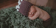 Jacksen joined the competition — help win amazing prizes! baby, newborn, sleeping, knit_hat, green_blanket, textured_blanket, cozy, portrait, infant, hat, peaceful, closeup, skin, wooden_background, soft_focus, studio, props, lying_down, nap, sleepy