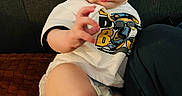 Jeremiah joined the competition — help win amazing prizes! baby, child, infant, tshirt, diaper, couch, furniture, person, skin, hand, face, eyes, sitting, indoors, curious, expression, clothing, leg, footwear, background