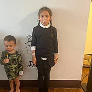 Ariel Rose joined the competition — help win amazing prizes! child, children, indoor, wall, floor, lollipop, braids, pajamas, camouflage, black_clothing, barefoot, wood_floor, wall_decor, serious_expression, standing, person, kids, toy, home, casual