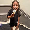 Ariel Rose joined the competition — help win amazing prizes! child, girl, ice_cream, smile, indoor, stairs, black_clothing, sneakers, long_hair, happy, holding, food, concrete_floor, metal_vent, railing, casual, portrait, young, joyful, person