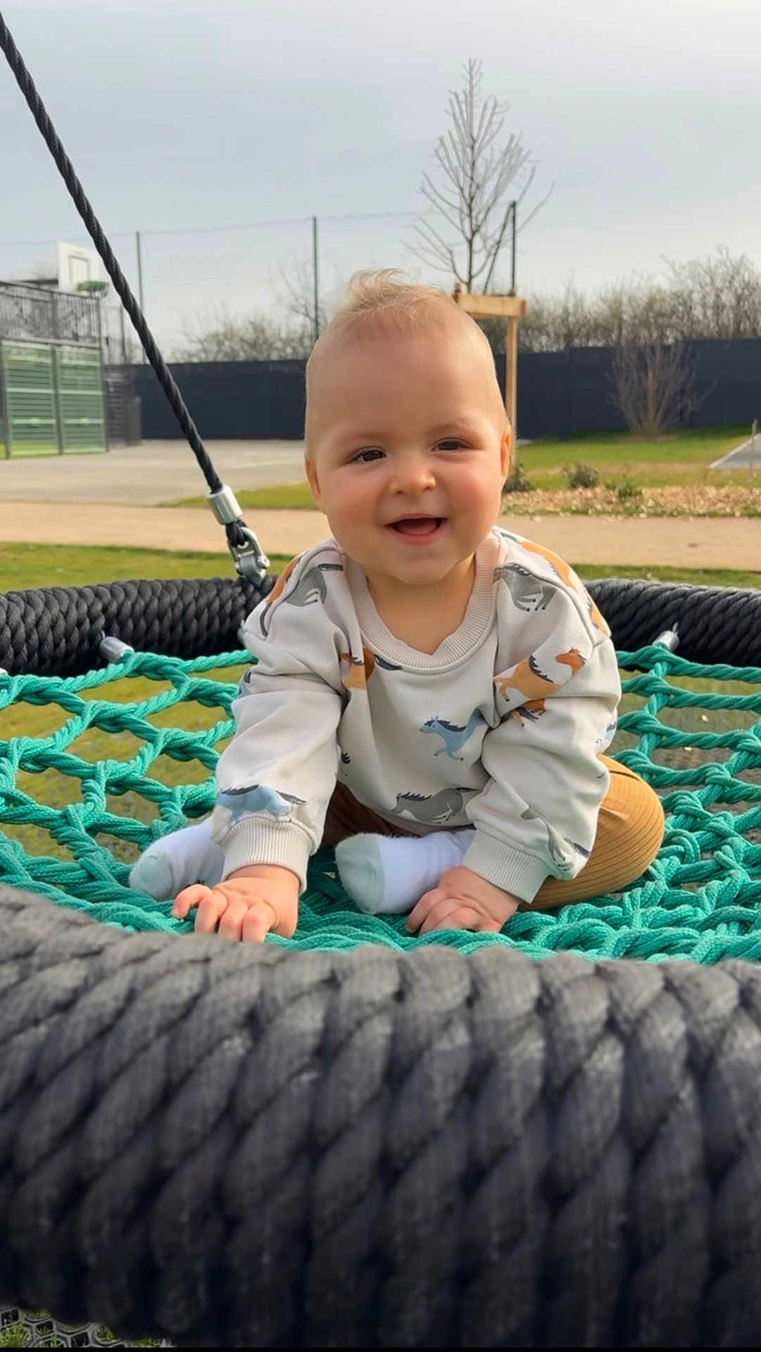 Simon a rejoint le concours — aidez-le/la à gagner de superbes lots ! baby, child, swing, outdoor, smiling, happy, net, rope, clothing, socks, grass, tree, playground, cute, person, infant, sweater, fun, park, nature