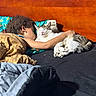 Milo is registered to the contest to win money with this photo: bed, bedroom, blanket, cat, child, cozy, cuddling, family, indoor, pet, pillow, portrait, relaxation, resting, sleeping, striped_fur, tabby_cat, warm_lighting, white_fur, wooden_headboard