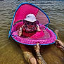 baby, child, float, water, lake, sunglasses, hat, sun_protection, tattoo, adult, summer, outdoor, recreation, fun, pink, canopy, floating_device, person, nature, water_sport