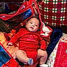 baby, blanket, celebration, child, christmas, cute, face, festive, gift_wrap, holiday, holiday_season, indoors, infant, lying_down, portrait, presents, red_clothing, smile, socks, soft_texture