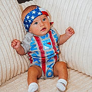 Luca joined the competition — help win amazing prizes! baby, infant, headband, stars_and_stripes, blue_eyes, sitting, plush_chair, cream_color, clothing, sock, cute, portrait, indoor, comfortable, furniture, small_hands, expression, child, new_york_rangers, patterned_clothing