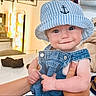 Luca joined the competition — help win amazing prizes! baby, child, face, smile, hat, bucket_hat, overalls, denim, indoor, person, hand, cute, blue, striped, anchor, infant, expression, clothing, portrait, holding