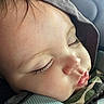 child, sleeping, face, close_up, hood, camo_clothing, eyelashes, lips, pout, cozy, cushion, texture, peaceful, resting, infant, baby, portrait, soft_light, indoors, cute