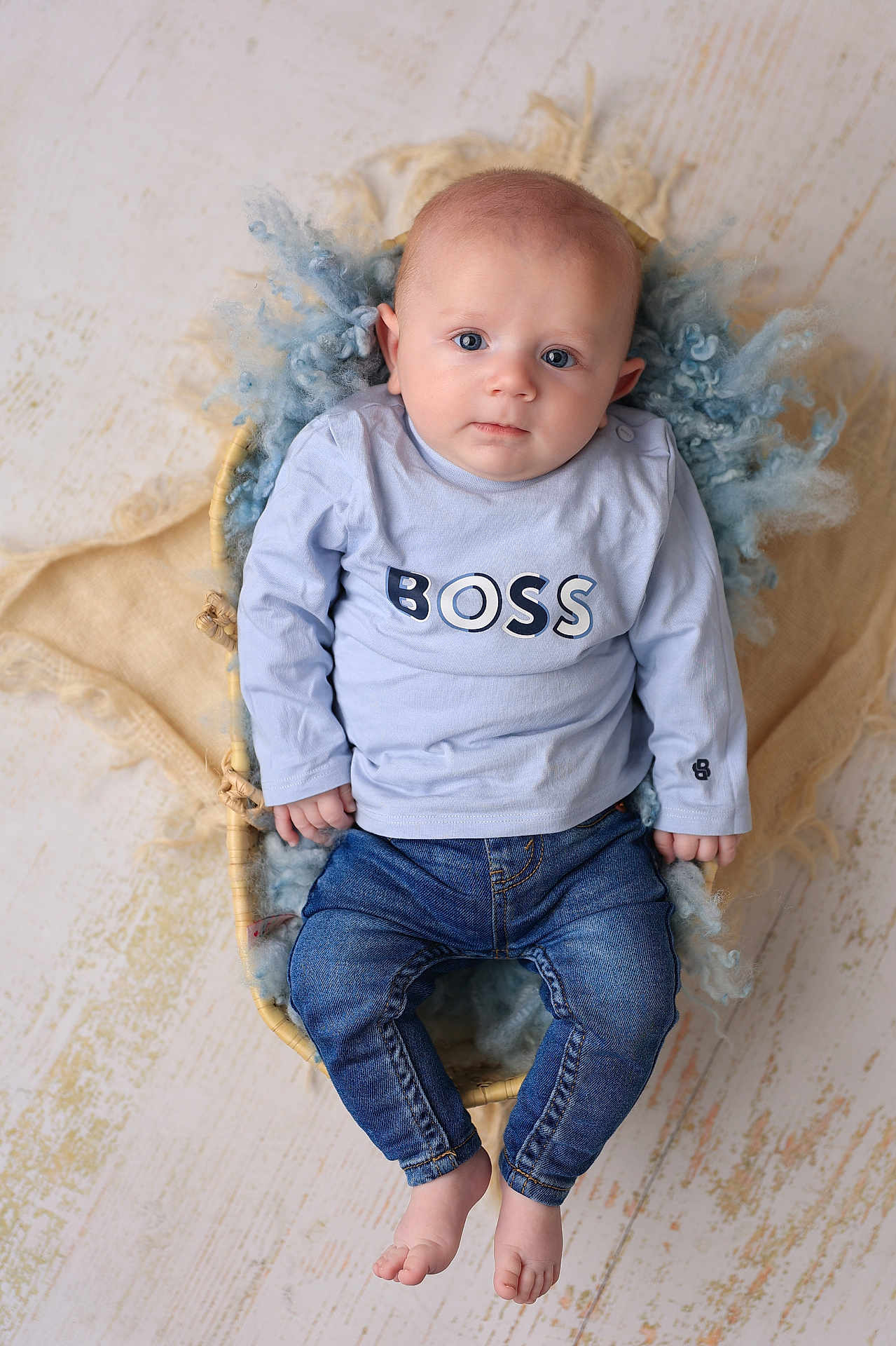 Maé participe au concours pour gagner de l'argent avec cette photo : baby, barefoot, basket, blue_shirt, casual_clothing, child, cute, denim_jeans, expression, face, floor, fluffy_wool, head, indoor, infant, light, looking_at_camera, portrait, sitting, young_child