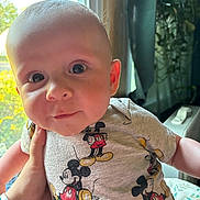 Rhonin joined the competition — help win amazing prizes! baby, child, infant, mickey_mouse, shirt, clothing, hand, window, natural_light, indoors, face, eyes, skin, cute, portrait, person, young, holding, expression, soft_light