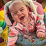 baby, infant, smiling, laughing, watermelon_print, sleeper, baby_seat, activity_center, toy, colorful, close_up, happy, cute, hand, face, padded_cushion, indoors, child, portrait, newborn