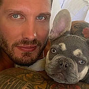 Mik is registered to the contest to win money with this photo: man, french_bulldog, dog, pet, selfie, portrait, bed, bedroom, cuddling, beard, tattoo, floral_tattoo, face, eyes, ears, wrinkles, indoor, close_up, companion, photography