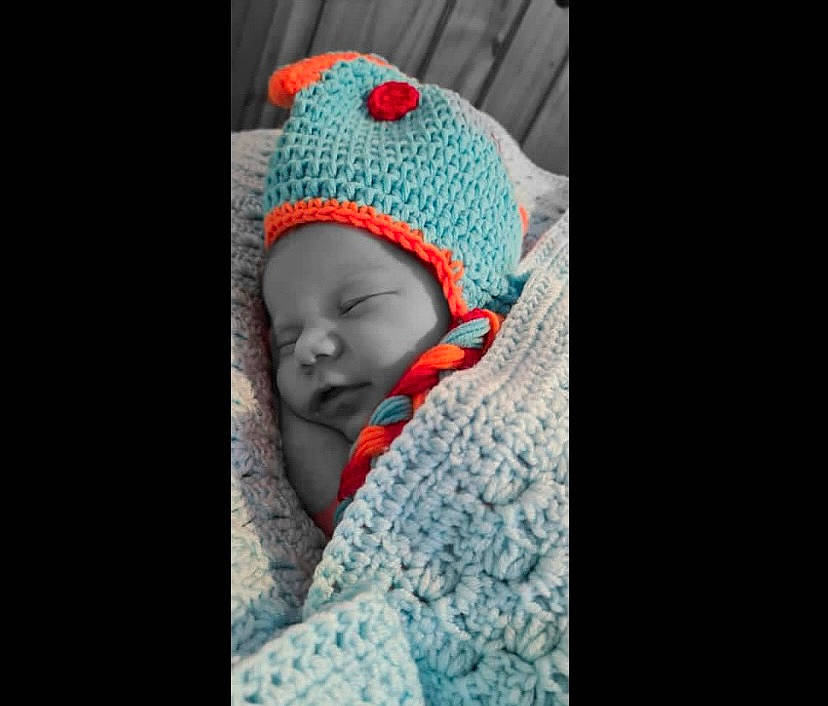 Louie is registered to the contest to win money with this photo: art, baby, baby_sleeping, baby_toddler_clothing, beanie, cap, carmine, child, comfort, electric_blue, eye, fashion_accessory, headgear, knit_cap, linens, pattern, person, portrait_photography, toddler, wool