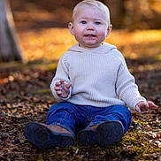 Masyn is registered to the contest to win money with this photo: autumn, boots, casual_clothing, child, daylight, expression, fall, forest, ground, jeans, leaves, nature, outdoor, portrait, seasonal, sitting, sunlight, sweater, toddler, young_child