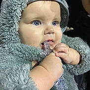 Mylo-Jay is registered to the contest to win money with this photo: baby, child, blue_eyes, fuzzy_clothing, hood, infant, chewing, hands, face, portrait, cute, closeup, skin, toy, warm_clothing, young_child, soft_texture, expression, person, indoors