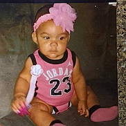 Myla is registered to the contest to win money with this photo: baby, child, infant, pink_clothing, headband, flower, pacifier, socks, sitting, couch, indoor, person, cute, chubby_arms, looking_away, soft_lighting, casual, home, portrait, young