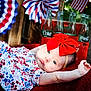 baby, infant, red_bow, blue_eyes, floral_dress, blanket, coca_cola, glass_bottles, patriotic, flags, decorations, outdoor, portrait, cute, celebration, summer, relaxing, holiday, headband, person