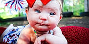 Avery joined the competition — help win amazing prizes! baby, child, red_bow, blue_eyes, blanket, outdoor, pinwheel, headband, face, closeup, portrait, infant, cute, smiling, skin, hand, resting, colorful, summer, nature