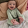 Nathan is registered to the contest to win money with this photo: baby, child, smiling, pajamas, bed, blanket, pillow, happy, infant, person, cute, foot, hand, striped_clothing, indoors, cozy, portrait, young_child, playful, sleepwear