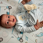 Nathan joined the competition — help win amazing prizes! baby, infant, onesie, teddy_bear, blue_clothing, blanket, golf_theme, toy, hand, face, eyes, lying_down, cute, child, indoor, soft_toys, patterned_blanket, smiling, young, playful
