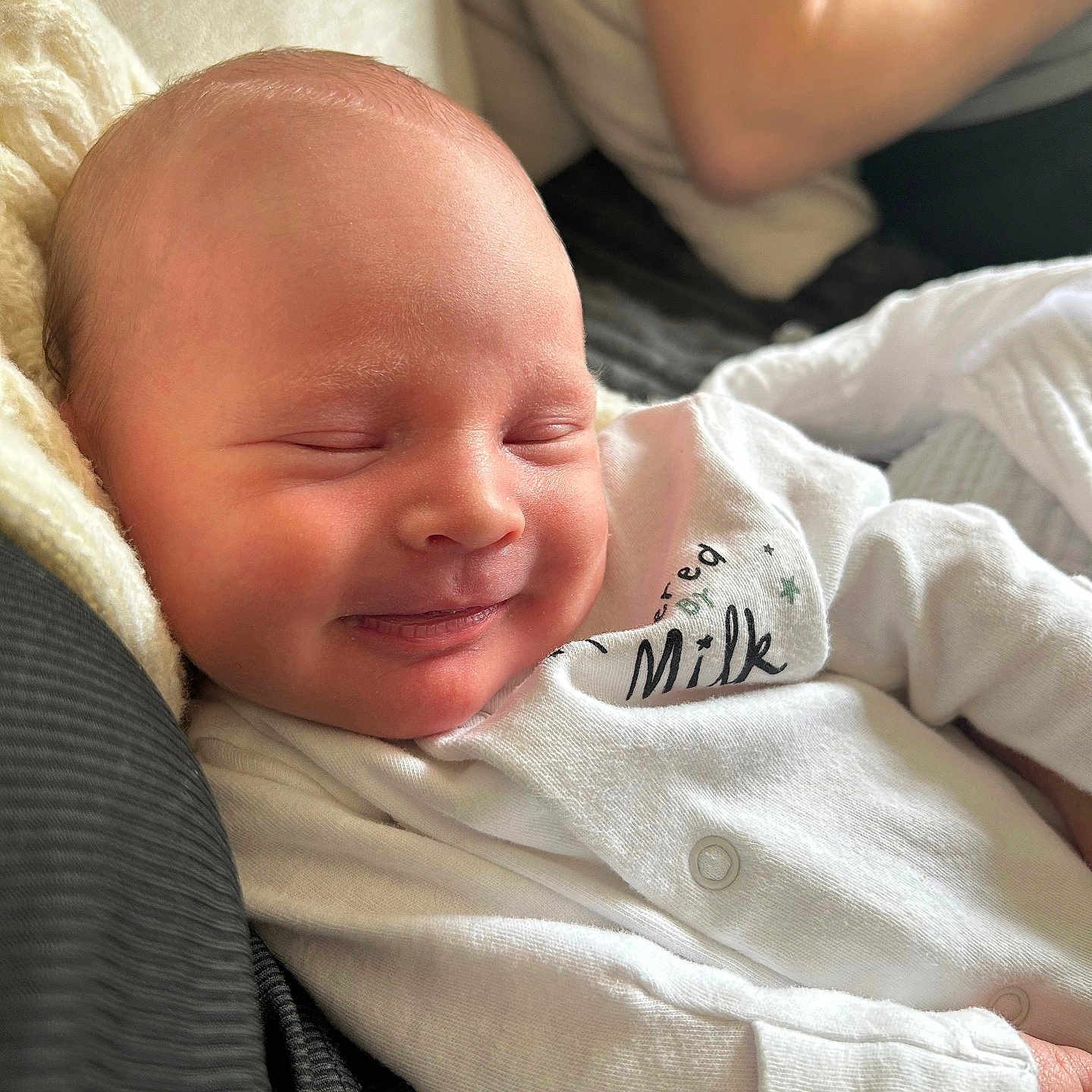 Theo is registered to the contest to win money with this photo: baby, blanket, clothing, couch, cushion, face, furniture, glove, happy, head, homedecor, knitwear, newborn, person, photography, portrait, quilt, sleeping, smile, sweater