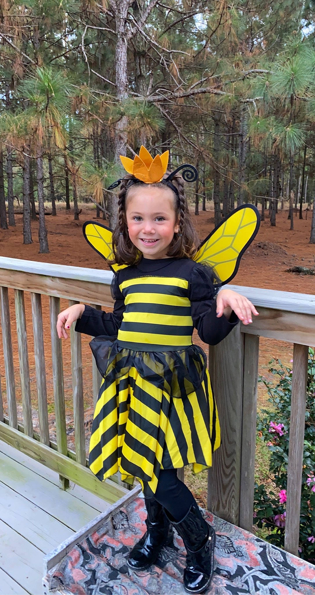Katalina is registered to the contest to win money with this photo: arthropod, bicycle_helmet, child, costume, costume_hat, fence, fun, happy, headgear, insect, joy, leisure, outerwear, people_in_nature, person, personal_protective_equipment, recreation, smile, t_shirt, toddler