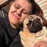 Frank participe au concours pour gagner de l'argent avec cette photo : woman, dog, pug, hug, smile, closed_eyes, sunlight, outdoor, wooden_wall, portrait, pet, friendship, affection, warmth, casual_clothing, close_up, happy, skin, fur, hand