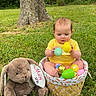 baby, child, easter_basket, plastic_eggs, stuffed_bunny, grass, tree_trunk, outdoor, greenery, yellow_shirt, cute, infant, spring, nature, playful, sitting, toy, holiday, celebration, person