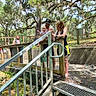 baby, child, adults, family, outdoor, nature, trees, Spanish_moss, staircase, metal_steps, handrail, zoo, park, wooden_fence, baby_clothing, man, woman, standing, travel, daylight