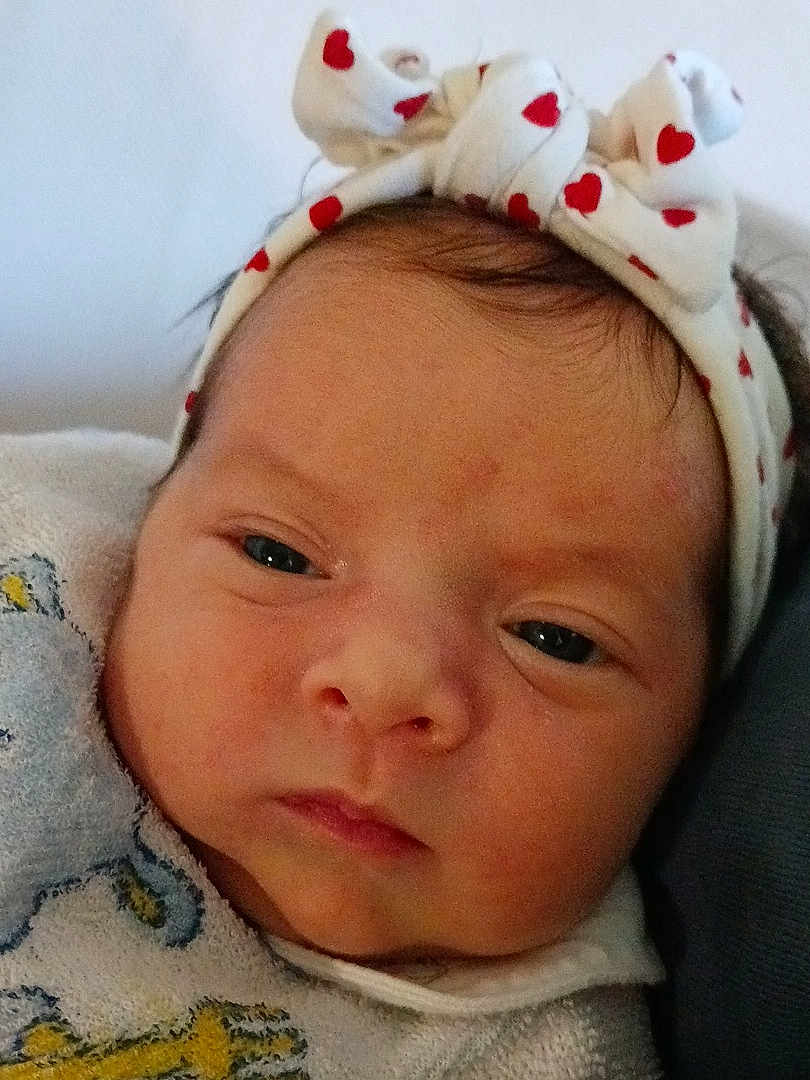 Melissa participe au concours pour gagner de l'argent avec cette photo : baby, infant, newborn, headband, heart_pattern, bow, face, eyes, nose, mouth, cheeks, blanket, fabric, closeup, portrait, skin, sleepy, indoor, cute, clothing