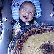 Angel is registered to the contest to win money with this photo: baby, car_seat, cookie_cake, smile, child, food, dessert, chocolate, happy, pillow, owl_pattern, seatbelt, cute, infant, indoor, plush, sweet, celebration, portrait, holding