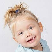 Lorena a rejoint le concours — aidez-le/la à gagner de superbes lots ! toddler, child, smiling, blonde_hair, blue_eyes, portrait, closeup, happy, casual_clothing, messy_ponytail, light_blue_shirt, cute, innocent, studio_lighting, white_background, person, face, young_child, baby_teeth, expression