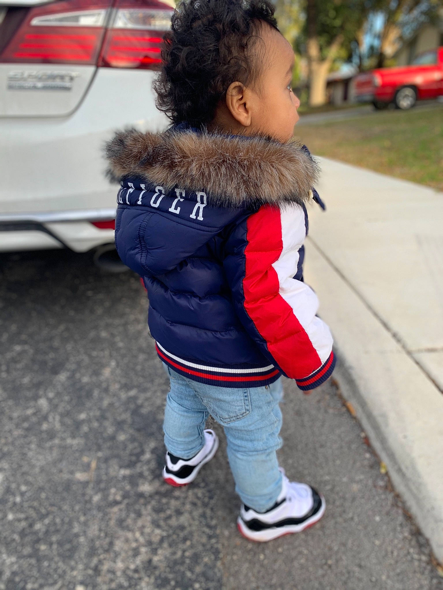 Kyrin joined the competition — help win amazing prizes! automotive_design, automotive_exterior, automotive_lighting, automotive_tire, bumper, car, face, hair, jacket, motor_vehicle, parking, person, personal_luxury_car, photograph, street_fashion, tire, toddler, tree, trunk, vehicle_door