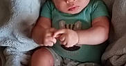 Carson is registered to the contest to win money with this photo: baby, infant, child, portrait, sitting, blanket, hat, beanie, clothing, green_shirt, shorts, socks, face, eyes, hands, fingers, cozy, indoor, cuddly, photography