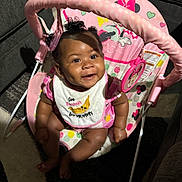 Chrissyah is registered to the contest to win money with this photo: baby, infant, smile, dimple, curly_hair, pink, bib, baby_rocker, minnie_mouse, toy, happy, cute, indoor, carpet, furniture, child, seat, clothing, person, cheerful