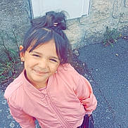 Jena participe au concours pour gagner de l'argent avec cette photo : child, girl, smiling, pink_jacket, white_sneakers, flower, handbag, pavement, stone_wall, outdoor, casual_clothing, happy, standing, young, hair_tied, earrings, urban, daylight, portrait, cute