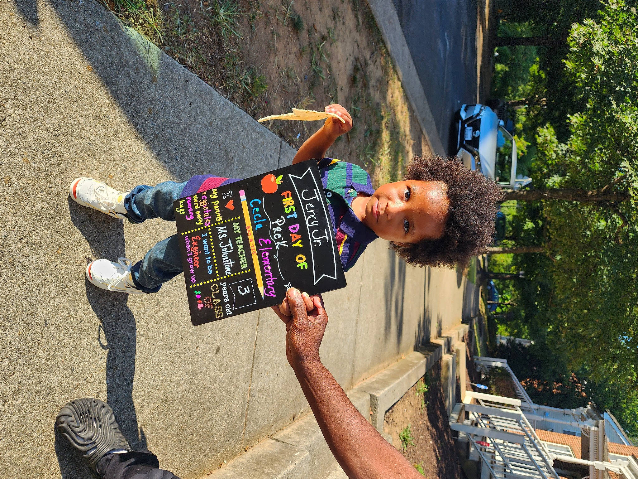 Jerry Jr is registered to the contest to win money with this photo: adventure, asphalt, boot, concrete, denim, electric_blue, fun, grass, happy, human_leg, leisure, pattern, person, plant, recreation, road_surface, shadow, toddler, travel, tree