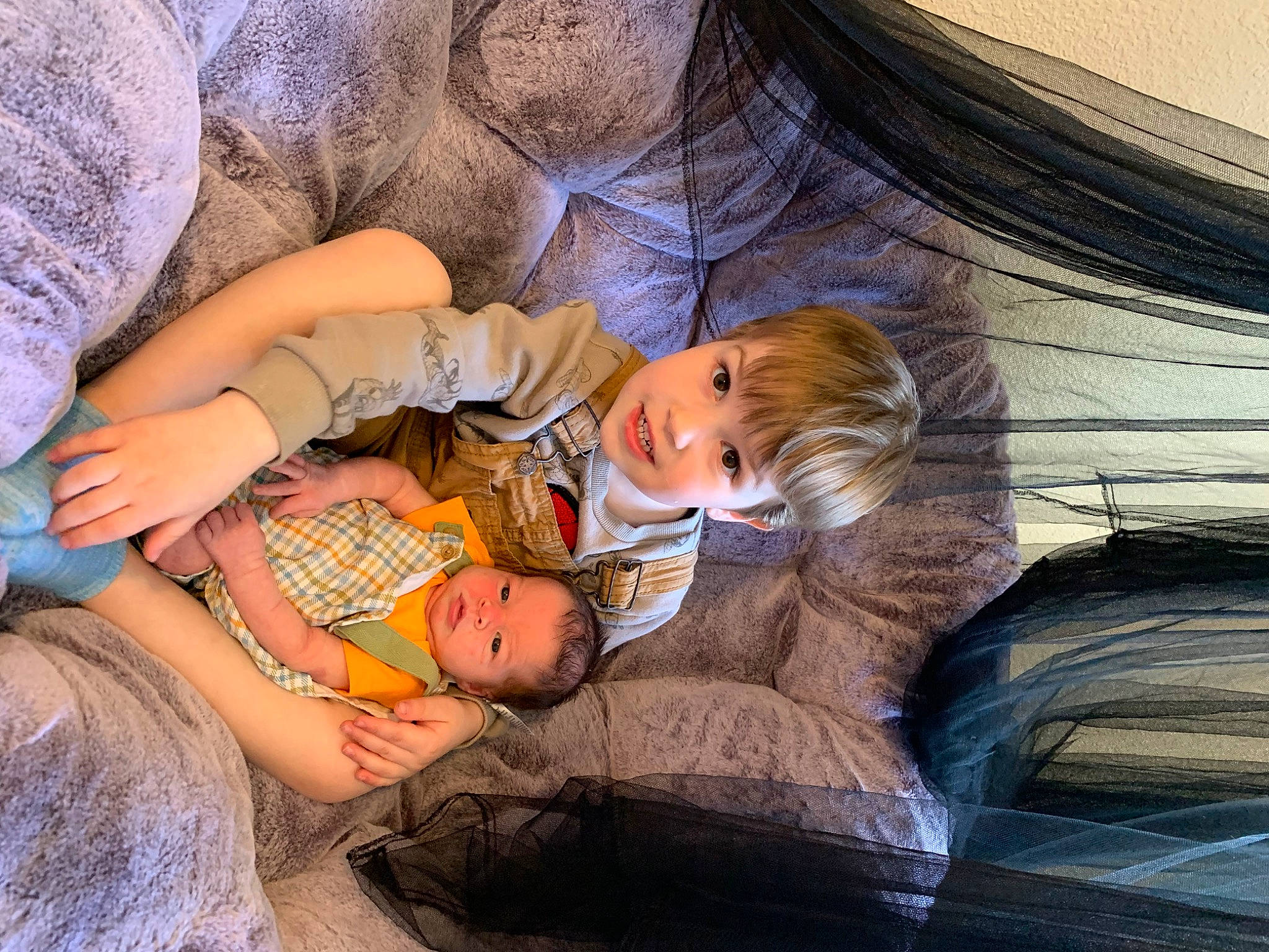 Oliver joined the competition — help win amazing prizes! abdomen, baby, blond, child, comfort, couch, grass, hand, human_body, lap, leg, person, product, room, sitting, skin, tints_and_shades, toddler, tree, trunk