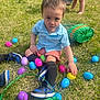 Miguel is registered to the contest to win money with this photo: toddler, child, grass, easter_eggs, basket, blue_shirt, orange_shorts, black_socks, sneakers, outdoor, spring, play, colorful, curious, toy, green_basket, pink_bucket, legs, hand, sunlight