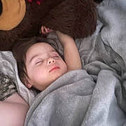 Miguel joined the competition — help win amazing prizes! child, sleeping, blanket, plush_toy, teddy_bear, bedtime, cozy, indoors, comfort, rest, peaceful, soft, face, person, young_child, nap, relaxation, covered, cuddly, cute