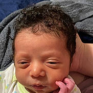 Dakari joined the competition — help win amazing prizes! newborn, baby, infant, face, hand, curly_hair, sleepy, blanket, soft, closeup, cute, skin, person, young, portrait, resting, indoors, cozy, clothing, sleepy_eyes